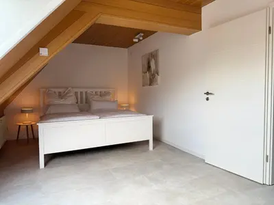 Ein Bett oder Betten in einem Zimmer der Unterkunft Rebenblick Dachsuite in historischem Gebäude aus 1840