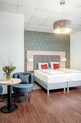 Ein Bett oder Betten in einem Zimmer der Unterkunft Pallas Hotels