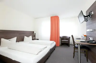 Ein Bett oder Betten in einem Zimmer der Unterkunft Hotel Weissach Am Neuenbühl