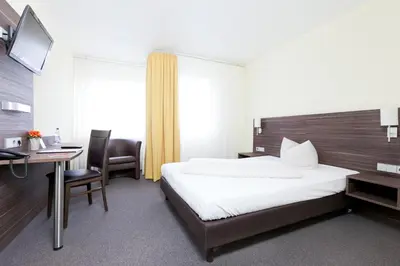 Ein Bett oder Betten in einem Zimmer der Unterkunft Hotel Weissach Am Neuenbühl