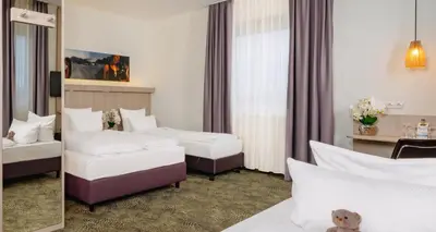 Ein Bett oder Betten in einem Zimmer der Unterkunft PLAZA INN Bad Rappenau