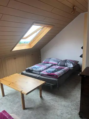 Ein Bett oder Betten in einem Zimmer der Unterkunft Dachgeschoss in einem Reihenhaus (mit gemeinschaftlichen Räumen)