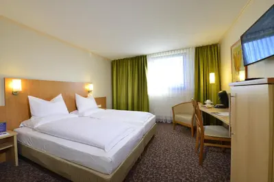 Ein Bett oder Betten in einem Zimmer der Unterkunft PLAZA INN Leonberg