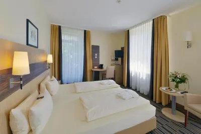 Ein Bett oder Betten in einem Zimmer der Unterkunft Kurpark-Hotel
