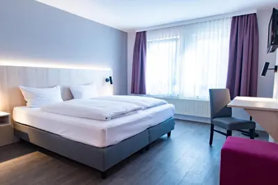 Ein Bett oder Betten in einem Zimmer der Unterkunft Taste Hotel Hockenheim